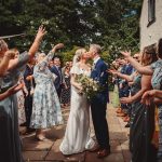 Bride and groom kissing at outdoor wedding ceremony.