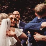 Wedding guests embracing and celebrating outdoors.