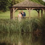 Couple in a gazebo by a pond.