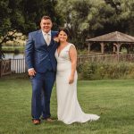 Couple in wedding attire in a garden setting.