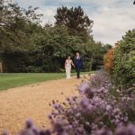 Couple walking on gravel path in garden.