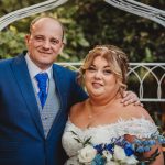 Bride and groom smiling outdoors on wedding day.