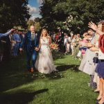 Happy couple walking down the wedding aisle outdoors.