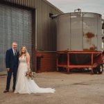 Bride and groom standing outside industrial building