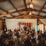 Rustic wedding reception with seated guests.