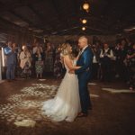 Couple dancing at wedding under fairy lights.