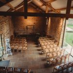 Rustic wedding ceremony setup in historic stone barn.