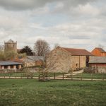 Rustic English countryside with stone buildings and church.