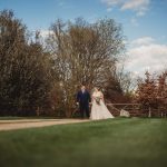 Bride and groom in garden setting.