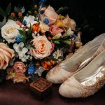 Elegant bridal shoes with floral bouquet and box.